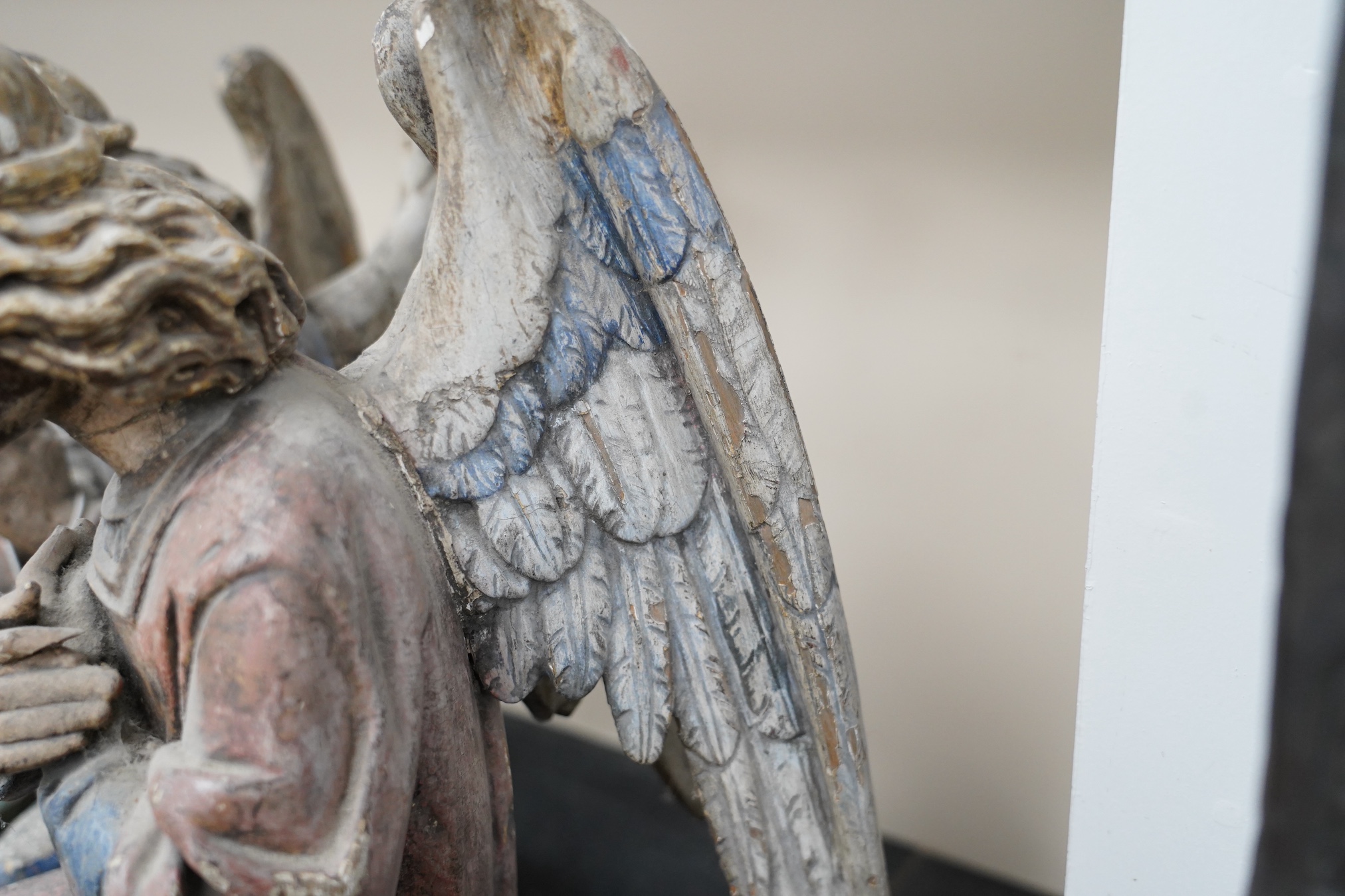 A pair of late 19th century polychrome carved painted pine praying archangels